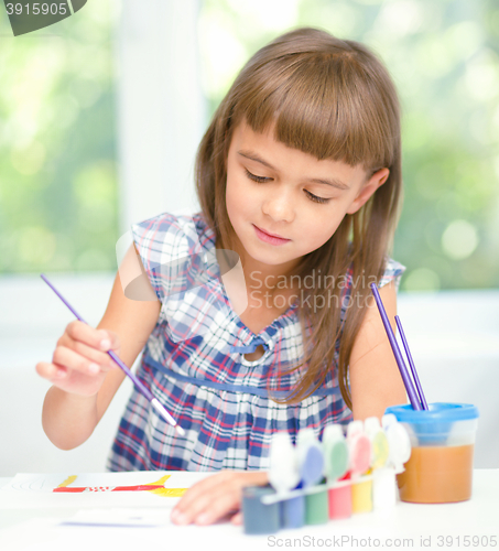 Image of Little girl is painting with gouache