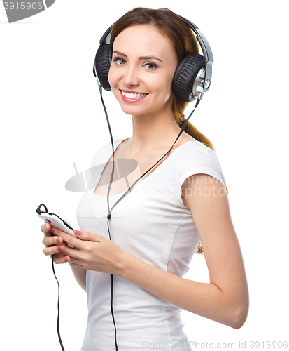 Image of Young woman enjoying music using headphones