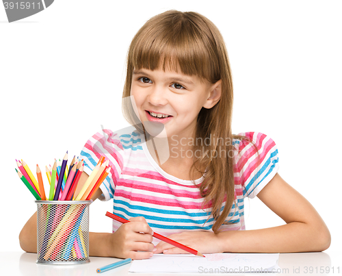 Image of Little girl is drawing using pencils