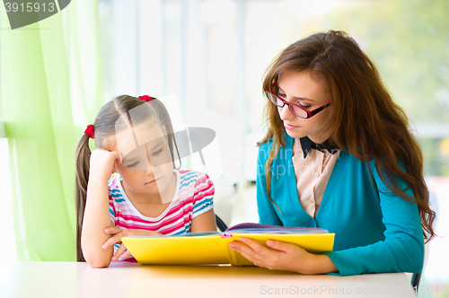 Image of Mother is reading book with her daughter