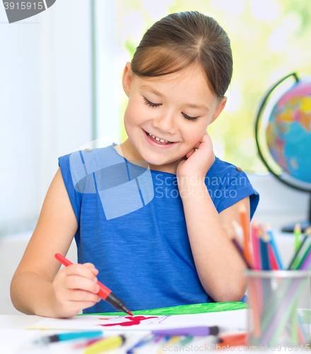 Image of Little girl is drawing using pencils