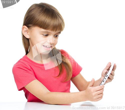 Image of Young cheerful girl is using tablet