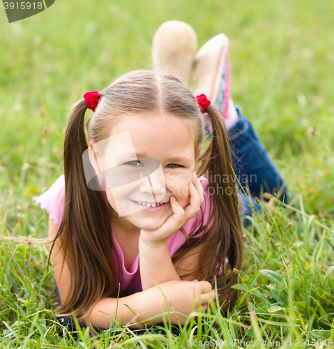 Image of Portrait of a little girl laying on green grass