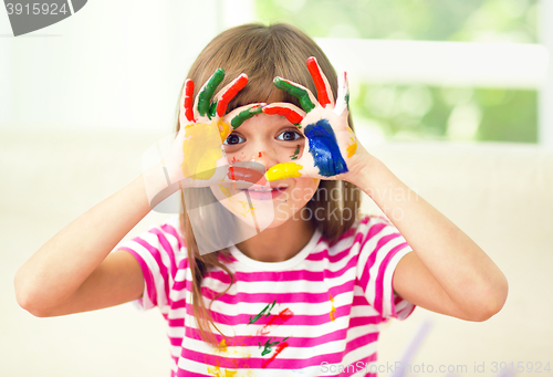 Image of Portrait of a cute girl playing with paints