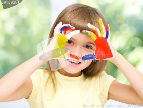 Image of Portrait of a cute girl playing with paints