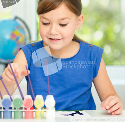 Image of Little girl is painting with gouache