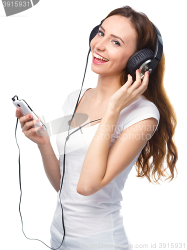 Image of Young woman enjoying music using headphones