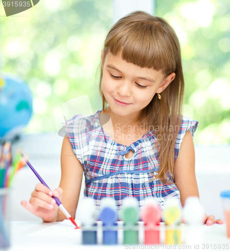 Image of Little girl is painting with gouache