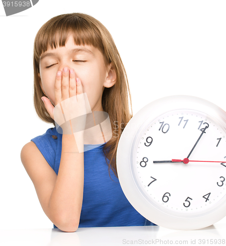 Image of Little girl is holding big clock