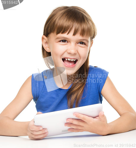 Image of Young cheerful girl is using tablet