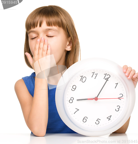 Image of Little girl is holding big clock