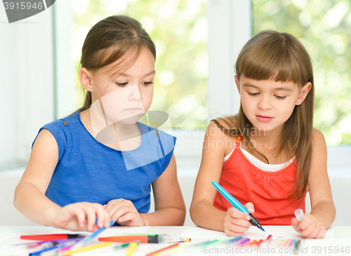 Image of Little girls are drawing using pencils