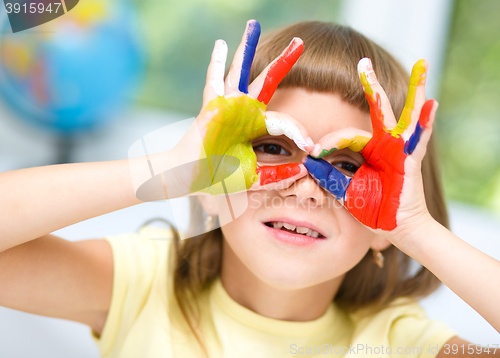 Image of Portrait of a cute girl playing with paints