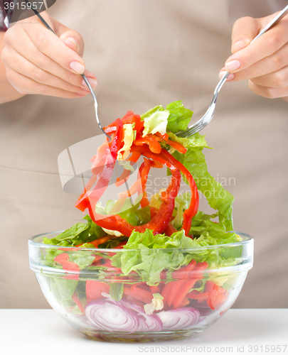 Image of Cook is mixing salad