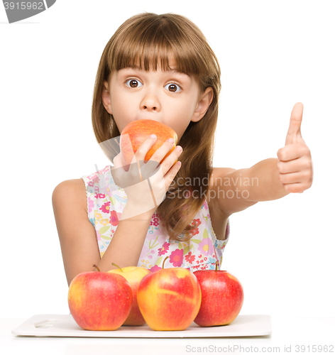 Image of Little girl with apples is showing thumb up sign