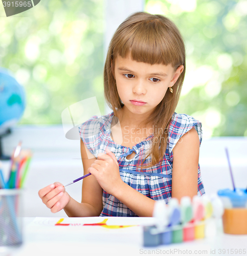 Image of Little girl is painting with gouache