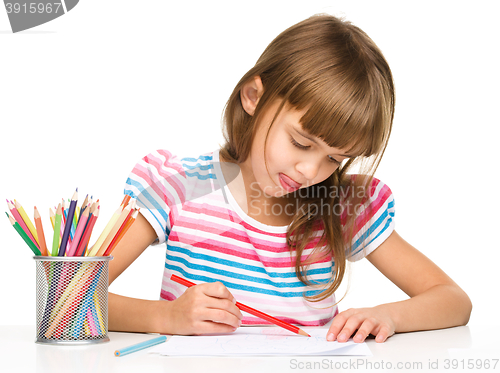 Image of Little girl is drawing using pencils