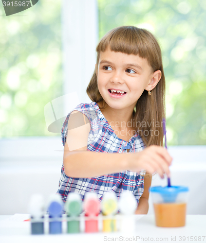 Image of Little girl is painting with gouache