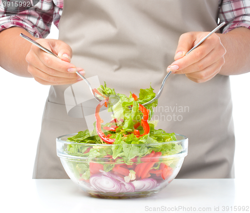 Image of Cook is mixing salad