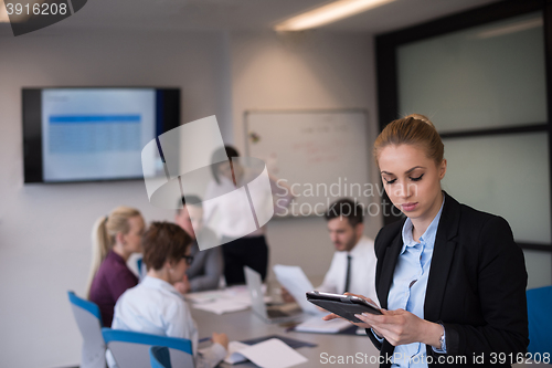 Image of business woman working on tablet at meeting room