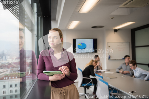 Image of blonde businesswoman working on tablet at office