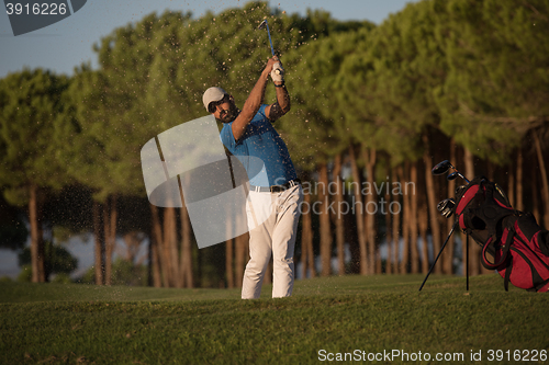 Image of golfer hitting a sand bunker shot on sunset