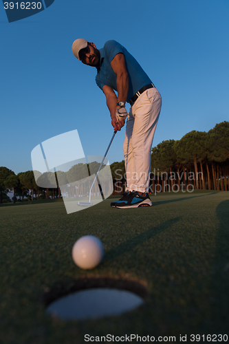 Image of golfer  hitting shot at golf course