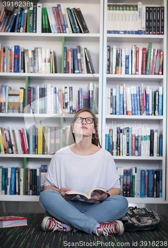 Image of famale student reading book in library