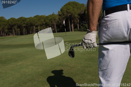 Image of golf player close up hand and driver from back