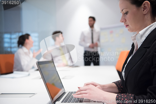 Image of young business woman on meeting  using laptop computer