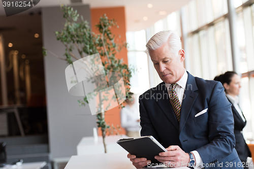 Image of senior business man working on tablet computer
