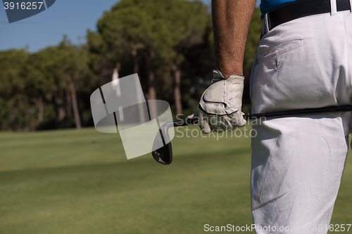 Image of golf player close up hand and driver from back