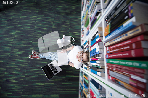 Image of female student study in library, using tablet and searching for 