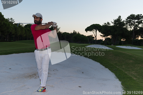 Image of golfer hitting a sand bunker shot on sunset