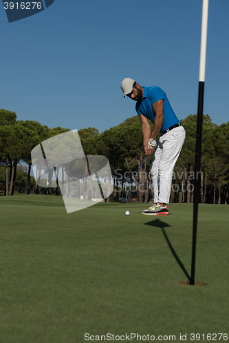 Image of golf player hitting shot at sunny day