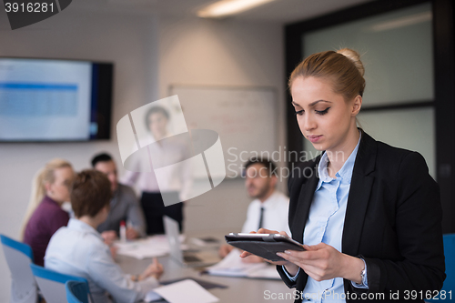 Image of business woman working on tablet at meeting room