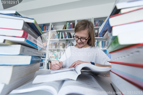 Image of female student study in library, using tablet and searching for 