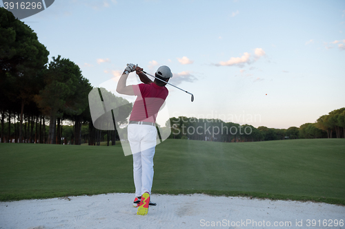 Image of golfer hitting a sand bunker shot on sunset