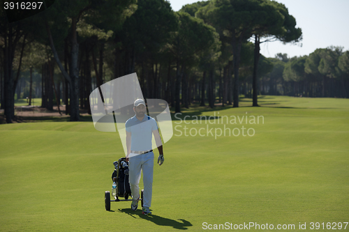 Image of golf player walking with wheel bag
