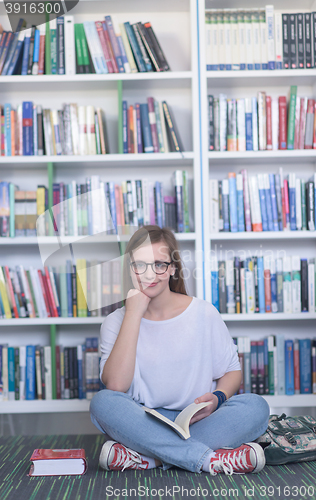 Image of famale student reading book in library