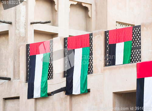 Image of UAE flags on traditional house