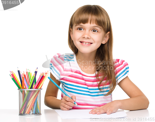 Image of Little girl is drawing using pencils