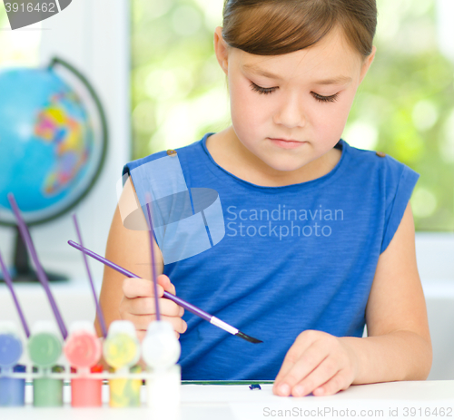 Image of Little girl is painting with gouache