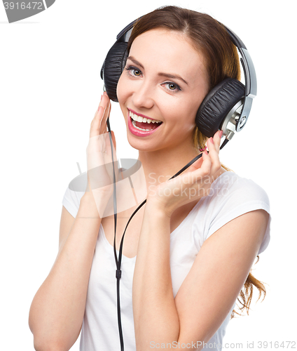 Image of Young woman enjoying music using headphones