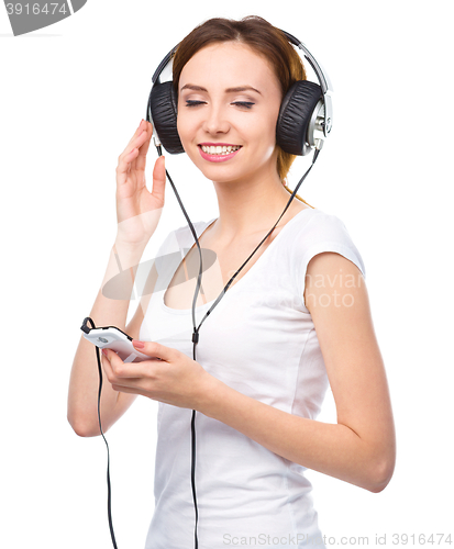 Image of Young woman enjoying music using headphones