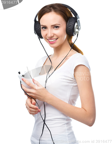 Image of Young woman enjoying music using headphones