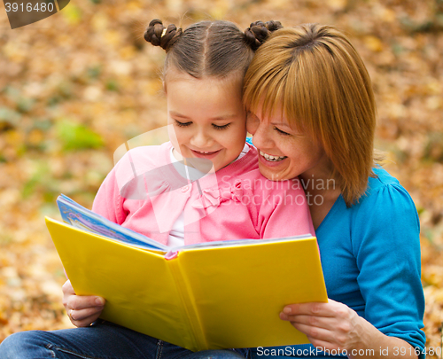 Image of Mother is reading book with her daughter