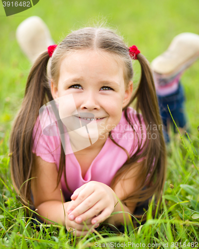 Image of Portrait of a little girl laying on green grass