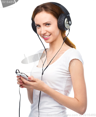 Image of Young woman enjoying music using headphones