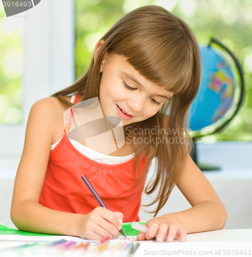 Image of Little girl is drawing using pencils
